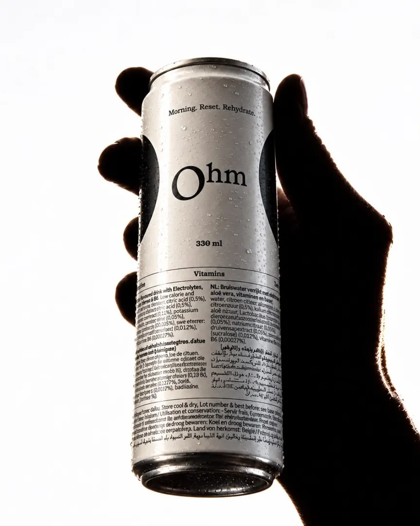 A hand holding an Ohm can against bright light